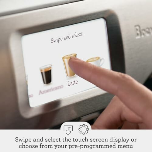 Hand selecting latte on coffee machine touchscreen.