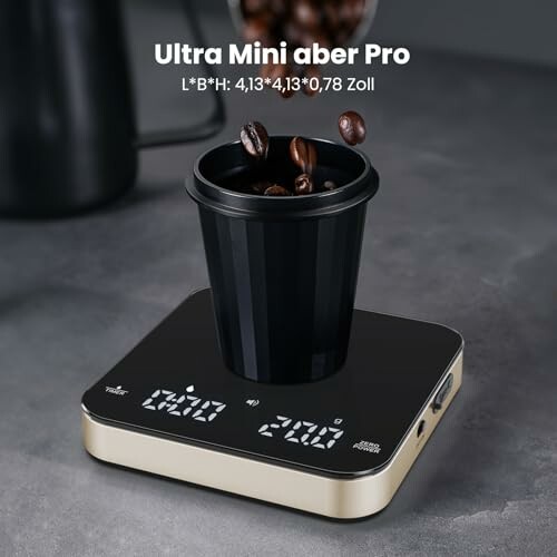 Small digital scale with a cup containing coffee beans on top.