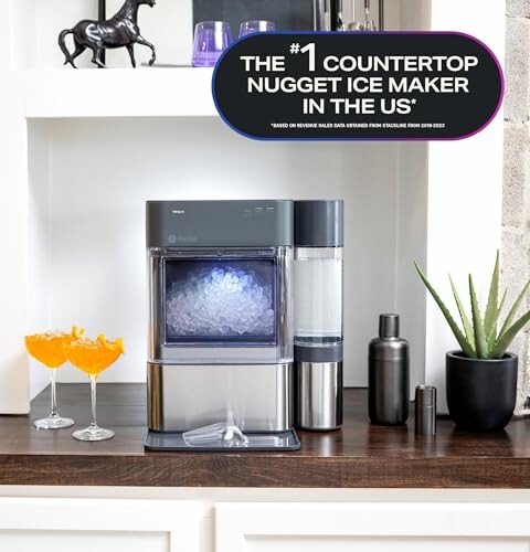 Countertop nugget ice maker on a shelf with drinks and decor.