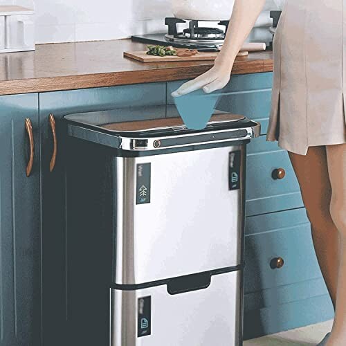 Person using a smart trash can in a kitchen