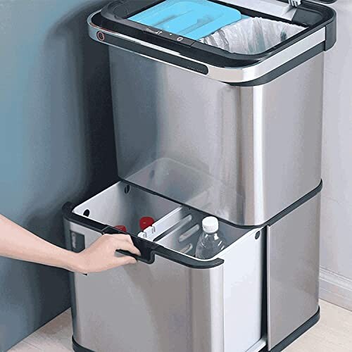 Stainless steel recycling bin with compartments being opened.